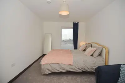 a bedroom with a bed with pillows and a window at Seaview City Lodge , 2- bedroom flat with Parking in Southend-on-Sea