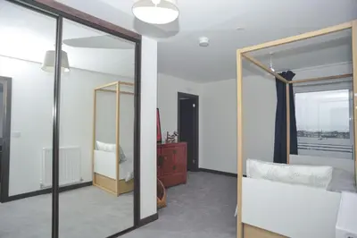 a room with a mirror and a bedroom at Seaview City Lodge , 2- bedroom flat with Parking in Southend-on-Sea