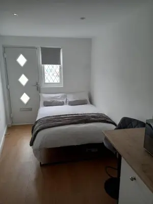 a bedroom with a bed and a window in it at The Southend Airport Lodge in Southend-on-Sea