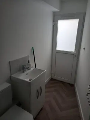 a white bathroom with a sink and a window at The Southend Airport Lodge in Southend-on-Sea