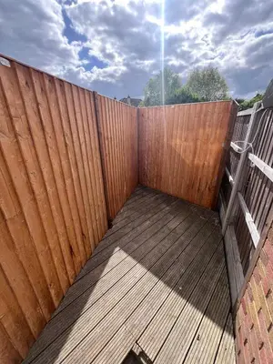 a wooden privacy fence with a wooden deck at The Southend Airport Lodge in Southend-on-Sea