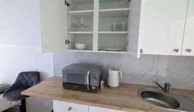 a kitchen counter with a microwave and a sink at The Southend Airport Lodge in Southend-on-Sea