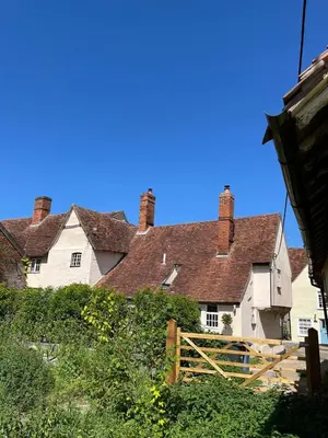 an old house with brick chimneys on top of it at Taper House - Cosy Medieval Cottage in Kersey