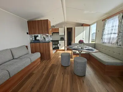 a living room with a couch and a table at Family Holiday Home with private terrace in Saint Osyth