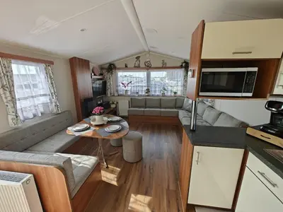 a living room with a couch and a table at Family Holiday Home with private terrace in Saint Osyth