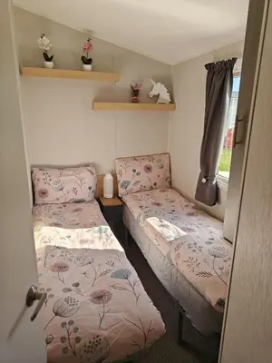 a small room with two beds and a window at Family Holiday Home with private terrace in Saint Osyth