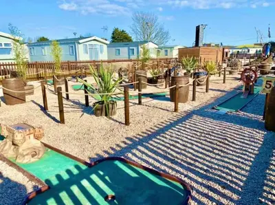 a park with a playground with a slide and trees at Family Holiday Home with private terrace in Saint Osyth