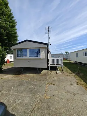 a small house with a large window in a driveway at Family Holiday Home with private terrace in Saint Osyth
