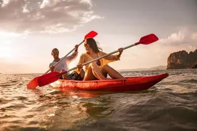 a man and woman in a red kayak in the ocean at Stunning Caravan At West Mersea Park 75192Wm in West Mersea