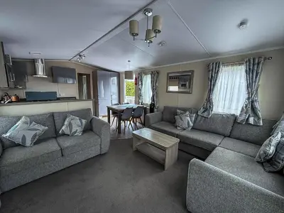 a living room with a couch and a table at Stunning Caravan At West Mersea Park 75192Wm in West Mersea