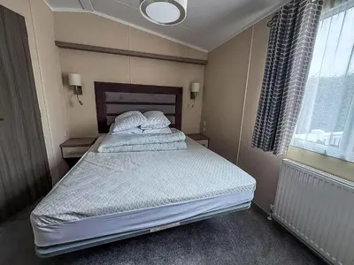 a bedroom with a large bed in a room at Stunning Caravan At West Mersea Park 75192Wm in West Mersea
