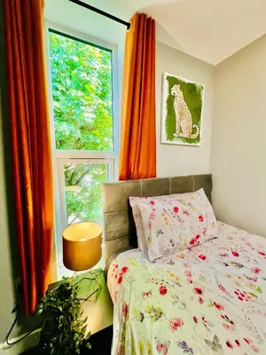 a bedroom with a bed and a window at Quirky and spacious 5 Bedroom and 3 bathroom house Sleeps 7 with free Parking in Basildon in Laindon