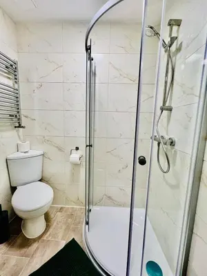 a bathroom with a shower and a toilet at Quirky and spacious 5 Bedroom and 3 bathroom house Sleeps 7 with free Parking in Basildon in Laindon