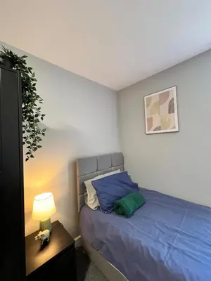 a bedroom with a blue bed and a lamp at Quirky and spacious 5 Bedroom and 3 bathroom house Sleeps 7 with free Parking in Basildon in Laindon