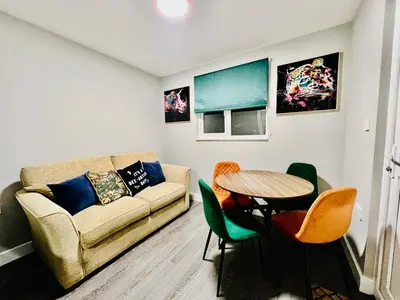 a living room with a couch and a table at Quirky and spacious 5 Bedroom and 3 bathroom house Sleeps 7 with free Parking in Basildon in Laindon