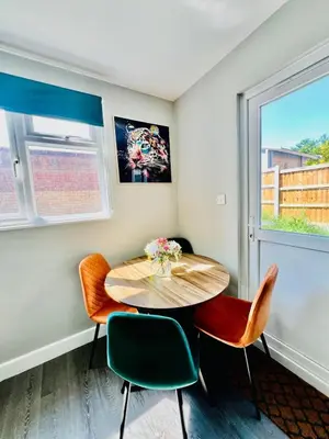 a dining room with a table and chairs and a window at Quirky and spacious 5 Bedroom and 3 bathroom house Sleeps 7 with free Parking in Basildon in Laindon