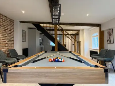 a pool table in a room with chairs at Family stay with soft play, hot tub, ping pong, pool table! in Hythe