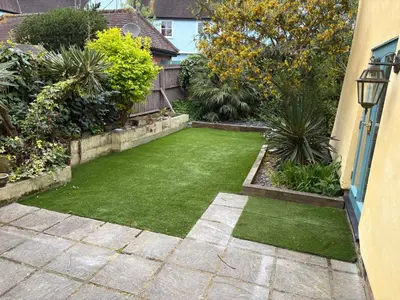 a small garden with green grass in a yard at Family stay with soft play, hot tub, ping pong, pool table! in Hythe