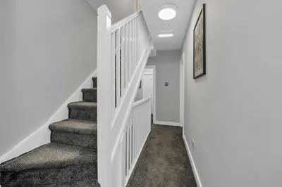 a hallway with a staircase with white walls at Weekly Deal- 4BDR House By Homestyles Hosts Short Lets & Serviced Accommodation Suffolk With Private En-Suite & Free Parking in Ipswich