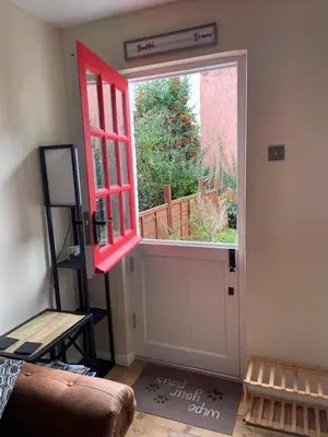 a room with a red door and a window at Cottage of Content in Wivenhoe