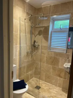 a bathroom with a shower and a toilet at Cottage of Content in Wivenhoe