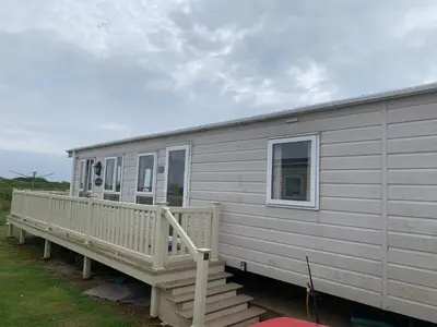 a mobile home with a porch and a deck at Verb View 6 Berth Caravan St Osyth Clacton-On-Sea in Saint Osyth