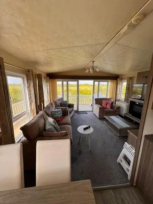 a living room with a couch and a table at Verb View 6 Berth Caravan St Osyth Clacton-On-Sea in Saint Osyth