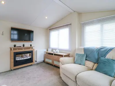 a living room with a couch and a tv at Bluebird in Clacton-on-Sea