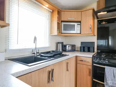 a kitchen with a sink and a microwave at Bluebird in Clacton-on-Sea