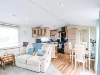 a living room with a couch and a kitchen at Bluebird in Clacton-on-Sea