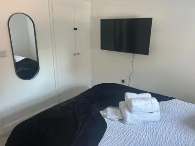 a bedroom with towels on a bed with a mirror at Upto 9 Contractors, LongStay Discounts in Hythe