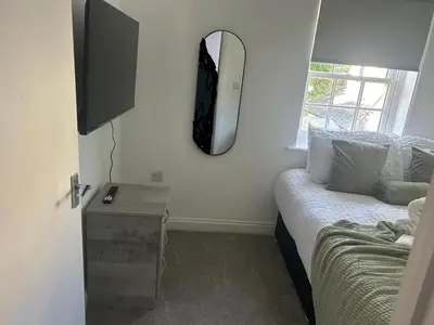 a room with a bed and a mirror on the wall at Upto 9 Contractors, LongStay Discounts in Hythe