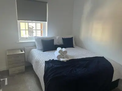 a bedroom with a bed with two towels on it at Upto 9 Contractors, LongStay Discounts in Hythe