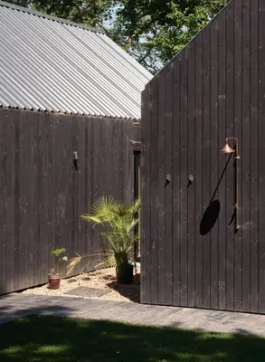 a black fence with a building and a plant at The Church Hall in Ipswich