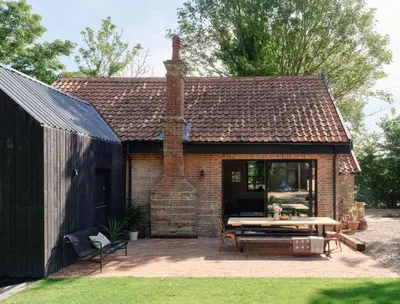 a small brick house with a picnic table outside at The Church Hall in Ipswich