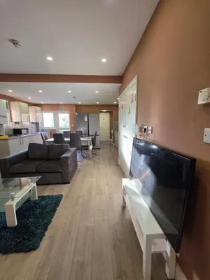 a living room with a couch and a flat screen tv at ELY Stay in Ipswich