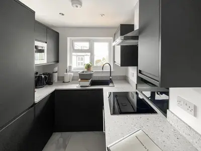 a kitchen with black cabinets and a sink at Thirslet in Maldon