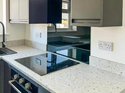 a kitchen with black and white counters and cabinets at Thirslet in Maldon