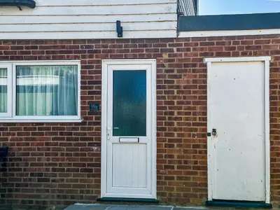 a brick building with a white door and windows at Thirslet in Maldon