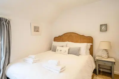 a bedroom with a white bed with towels on it at Seahorse Cottage, Aldeburgh - sleeps 4 - Adult only property - Managed by Aldeburgh Coastal Cottages in Aldeburgh