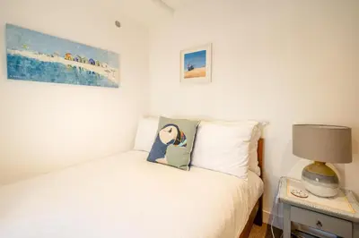 a bedroom with a bed and a lamp on a table at Seahorse Cottage, Aldeburgh - sleeps 4 - Adult only property - Managed by Aldeburgh Coastal Cottages in Aldeburgh