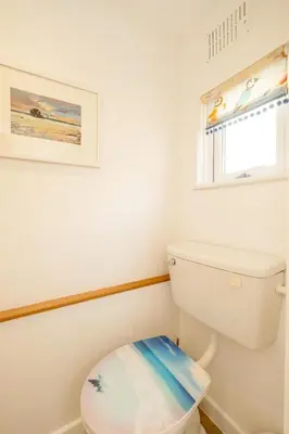 a bathroom with a white toilet and a window at Seahorse Cottage, Aldeburgh - sleeps 4 - Adult only property - Managed by Aldeburgh Coastal Cottages in Aldeburgh