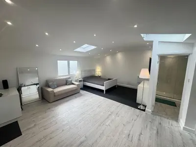 a living room with a couch and a bed at The Studio Guesthouse in Little Burstead