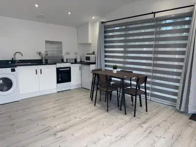 a kitchen with a table and chairs in a room at The Studio Guesthouse in Little Burstead