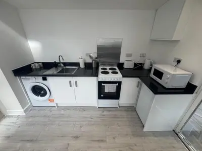 a small kitchen with a stove and a microwave at The Studio Guesthouse in Little Burstead