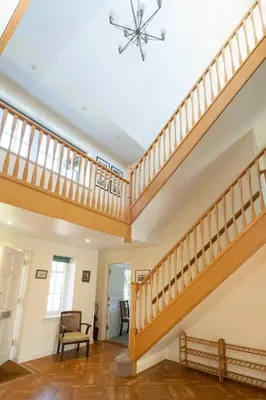 a staircase in a house with wooden railings at Claysmead - A large Lakeside House in Thorpeness - Aldeburgh Coastal Cottages in Thorpeness