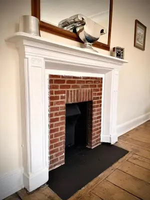 a red brick fireplace with a white mantel at Churchgate Apartment in Bury Saint Edmunds