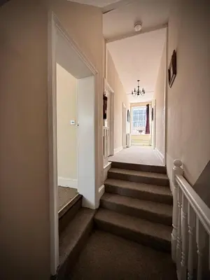 a hallway with stairs in a home at Churchgate Apartment in Bury Saint Edmunds