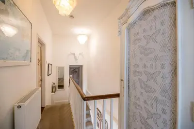 a hallway with a staircase with a wall mural of birds at La Ronessa, Aldeburgh in Aldeburgh