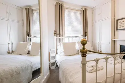 a bedroom with two beds and a mirror at La Ronessa, Aldeburgh in Aldeburgh